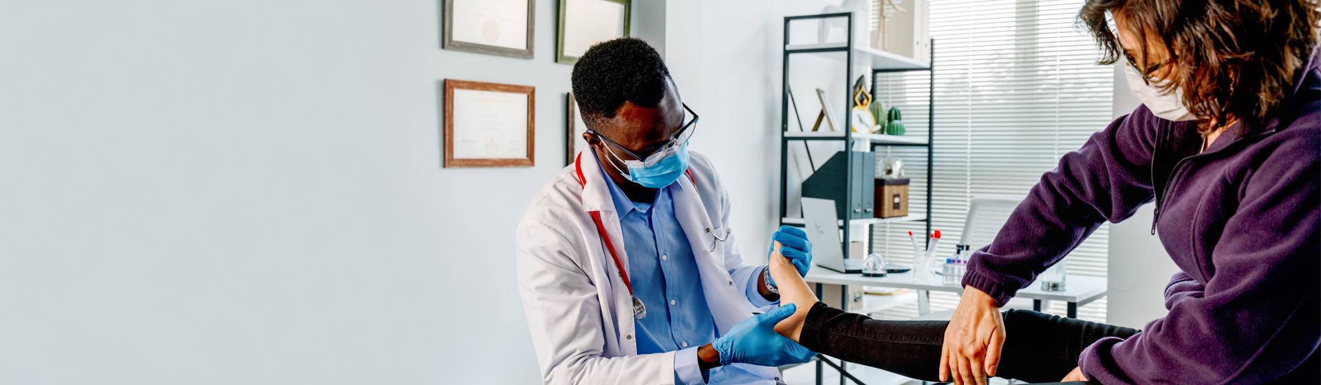 Podiatrist reviews patient's ankle in medical office